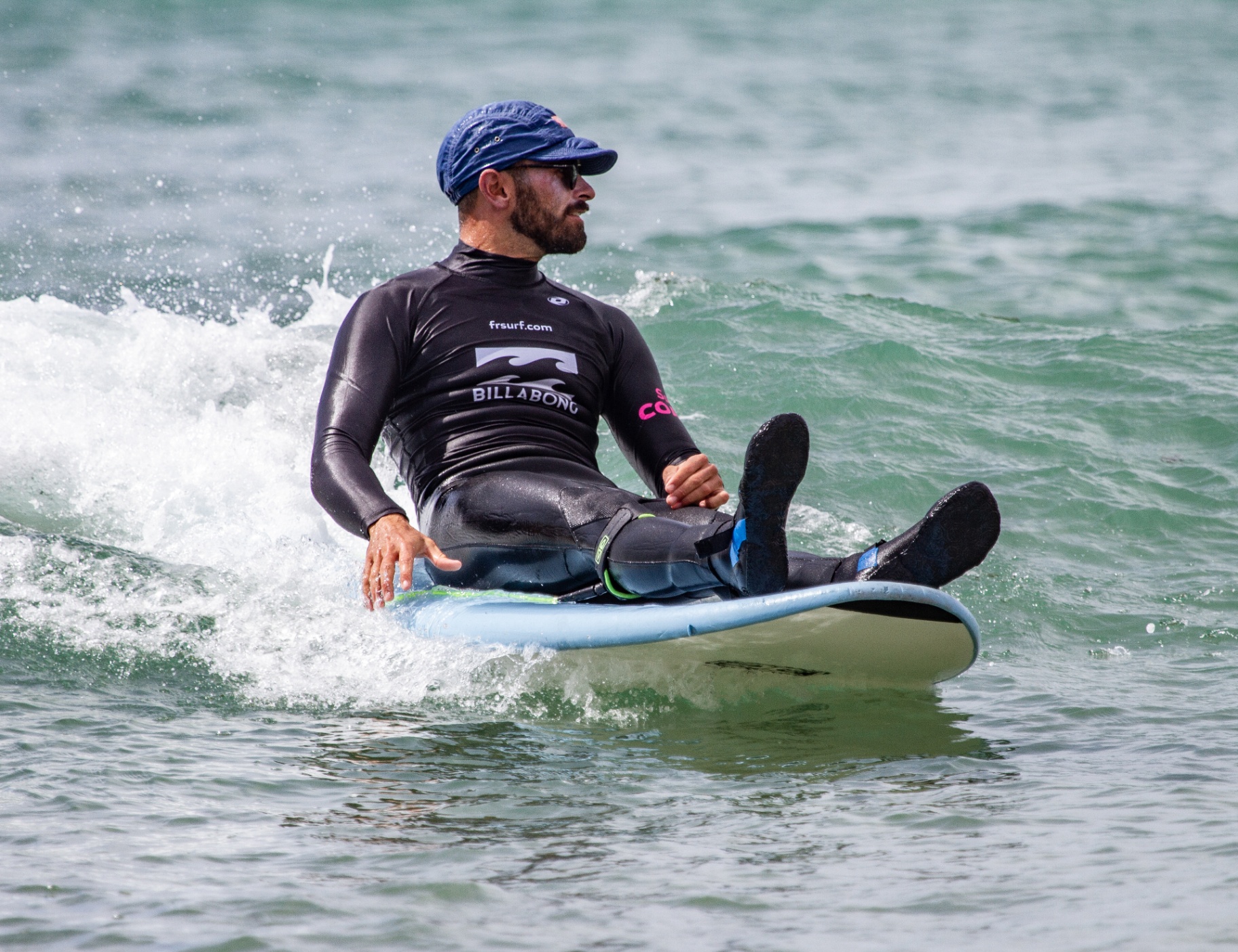 Surfer at Sagres with the cliffs of the south-west Algarve in the background